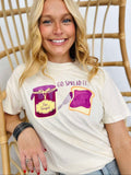 Person wearing a white t-shirt with graphics and text "Go spread it", sitting on a wicker chair.