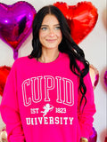 A person wearing a pink sweatshirt with the text 'CUPID UNSUCCESSFUL SINCE 1823' and a graphic of a cupid, surrounded by heart-shaped balloons.
