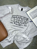 Gray sweatshirt with If the stars were made to worship so will I on a gray surface next to a brown bag and open Bible.