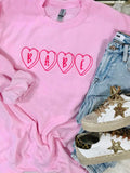 A pink embroidered sweatshirt with the word 'BABE' in heart shape on the front, displayed flat with a pair of blue jeans and white sneakers on top.