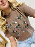 Woman wearing a Espresso t-shirt with duck bow designs on a white background