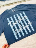 Blue t-shirt with 'Everything Hallelujah' text on a white surface