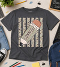 Gray t-shirt with a pencil graphic and 'CONNOR' text, surrounded by school supplies on a light surface.