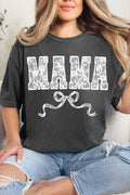 A person wearing a black t-shirt with the text 'MAMA' printed in white, decorated with a white lace-style pattern and a bow at the bottom.